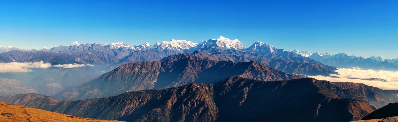 Trekkers on a snow ridge above the clouds in the Khumbu