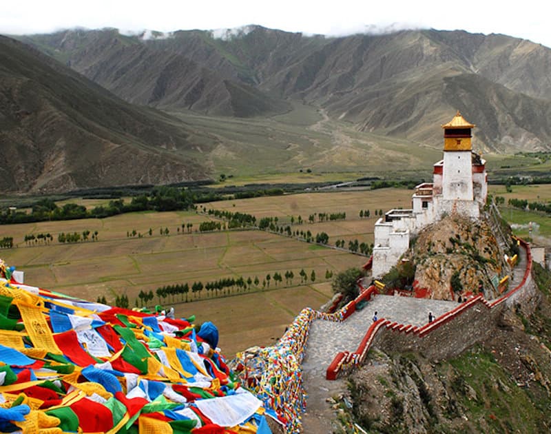 Tibetan plateau with a turquoise lake and distant peaks
